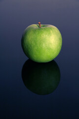 green isolated apple on blue reflective background