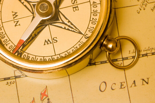 Old style brass compass on antique  map