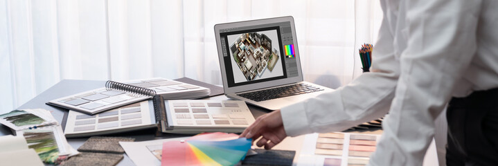 Interior architect designer at table designing hand choosing color samples with architecture...