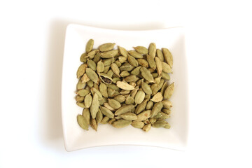 cardamon in square white bowl isolated