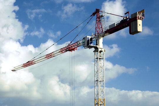 High rise crane with a cloudy blue sky backdrop