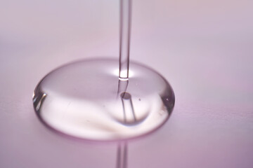 A juicy drop of gel on a purple background.