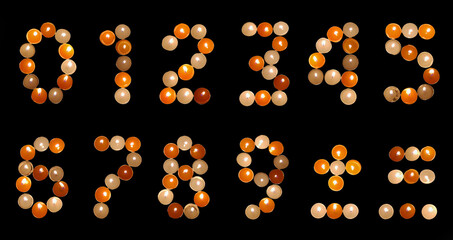 numeral font formed of multicoloured tea candles (isolated on black)