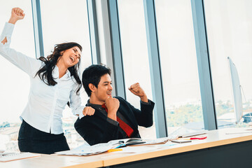 Two happy business people celebrate at office meeting room. Successful businessman congratulate...