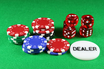 Poker chips and 5 dice on a green baize