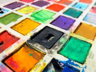 closeup of child's old tin toy paintbox with the brilliant colours of childhood; wideangle view;...