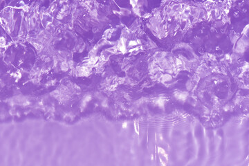 Purple water with ripples on the surface. Defocus blurred transparent pink colored clear calm water surface texture with splashes and bubbles. Water waves with shining pattern texture background.