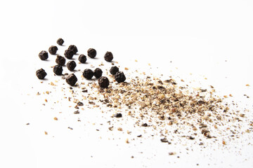 whole and ground black pepper on white