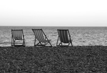 Deck chairs on the pebble beach of Beer, Devon.