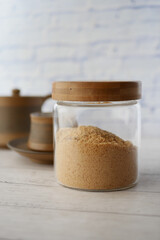 brown sugar in a jar and cup of tea on table ,