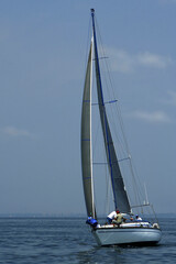 Fototapeta premium Regatta. Sports. The team of a yacht changes sails. The yacht should be floating faster.