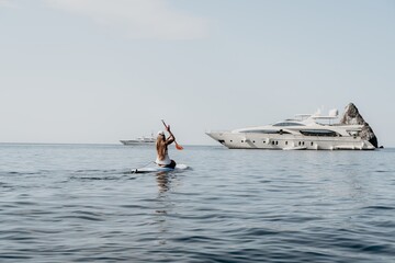 Woman sea sup. Close up portrait of happy young caucasian woman with long hair looking at camera...