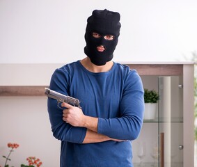 Male robber stealing valuable things from the house