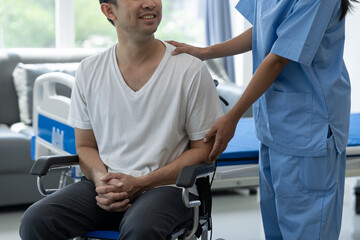 Rehabilitation specialist or physiotherapist giving physical training instruction to male patient in wheelchair at rehabilitation center The concept of physical therapy and health insurance.