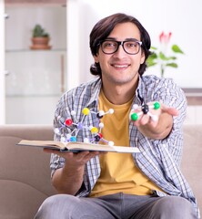 Young student physicist preparing for exam at home