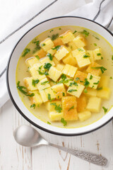 Zuppa Imperiale Italian Imperial soup with eggs and Parmesan cheese, dish of Emilia Romagna closeup on the plate on the table. Vertical top view from above