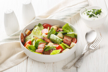 BLT salad with romaine lettuce, pieces of crispy bacon, tomatoes, crunchy croutons, and a creamy...