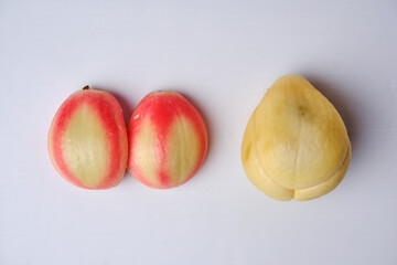 two slightly reddish zalacca or Salacca zalacca fruits and slightly off-white salak fruit which have been peeled