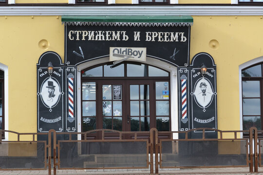 Rybinsk, Russia - 08 13 2021: Decoration of the facade and showcase of a men's haircut and shave salon in retro style.