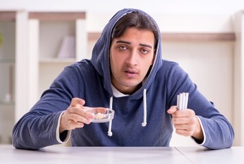 Young man having problems with narcotics at home