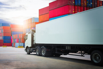 A White trailer Trucks Parked with Stacked of Containers Cargo Shipping. Handling of Logistics Transportation Industry. Cargo Container ships, Freight Trucks Import-Export. Distribution Warehouse.