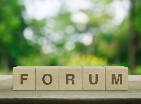 Forum letter on wood block cubes on wooden table over blur tree in park, Business communication concept