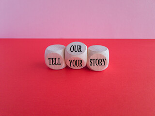 Tell our or your story. Turned wooden cubes and changed words tell our story to tell your story. Beautiful red table, pink background, copy space. Business, storytelling and our or your story concept.