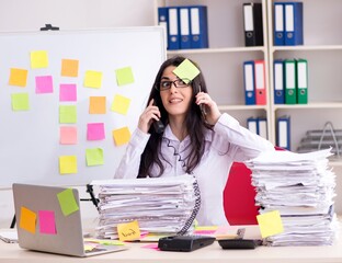 Young female employee in conflicting priorities concept