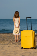 woman on the beach with a suitcase