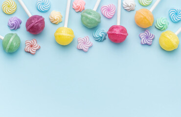 Sweet lollipops and candies on blue background