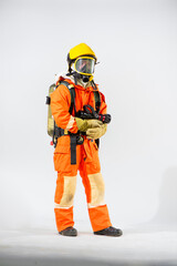 Professional firefighter standing holding fire hose with both hands and looking to the camera on white background.