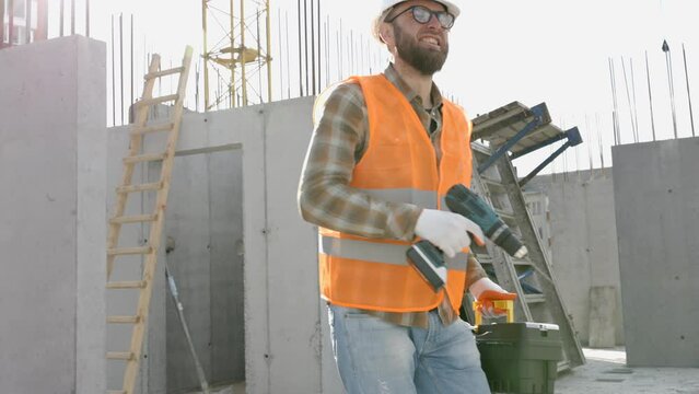Funny construction worker dancing. Positive dance of builders in helmet. Construction engineer in builder uniform dancing on his work place