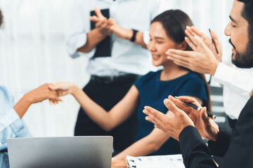 Diverse coworkers celebrate success with handshake and teamwork in corporate workplace....