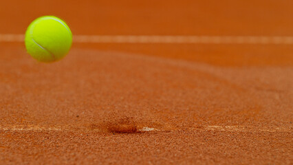 Close up of Tennis ball ping on clay court inside or outside white line