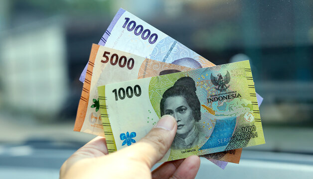 Indonesian man hand holding rupiah money. Indonesian currency. cash in hand concept and close up view