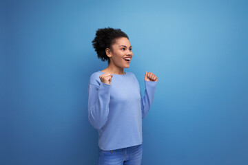 close-up of a young successful dark-skinned woman with puffy hair in blue clothes isolated...
