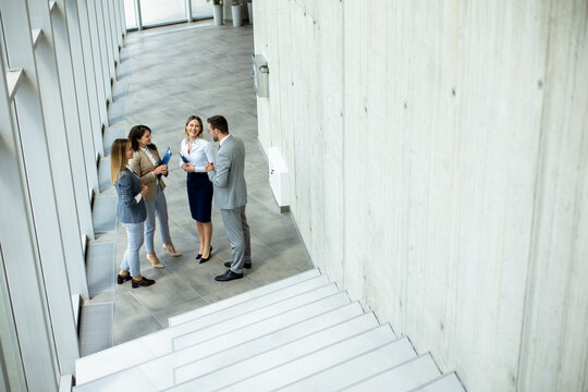 Young startup team have a discussion by stairs in the office corridor
