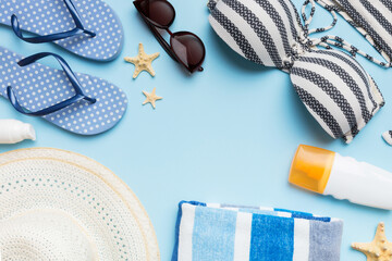 Woman swimwear and beach accessories flat lay top view on colored background Summer travel concept. bikini swimsuit, straw hat and seasheels. Copy space Top view
