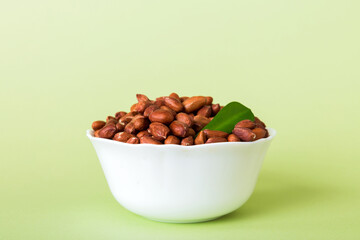 Naklejka na ściany i meble Fresh healthy peanuts in bowl on colored table background. Top view Healthy eating bertholletia concept. Super foods