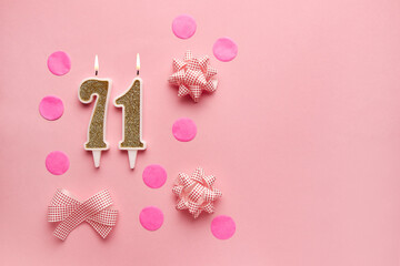 Number 71 on pastel pink background with festive decor. Happy birthday candles. The concept of celebrating a birthday, anniversary, important date, holiday. Copy space. banner