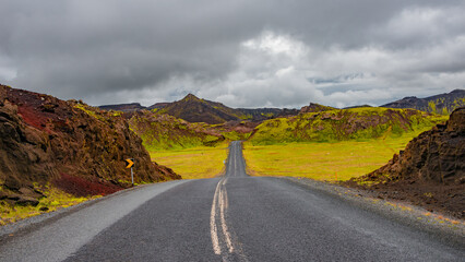 Panoramic over a paved road and dramatic Icelandic colorful and wild landscape at summer time, Iceland