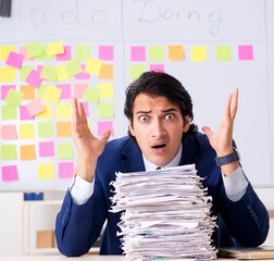 Young handsome employee in front of whiteboard with to-do list