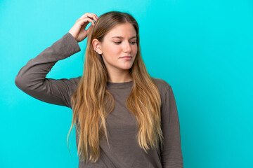 Fototapeta premium Young blonde woman isolated on blue background having doubts while scratching head