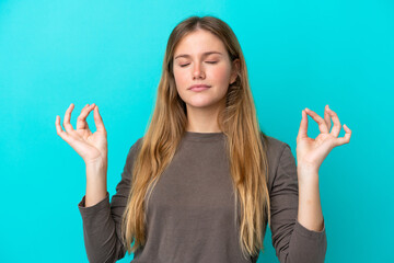 Young blonde woman isolated on blue background in zen pose