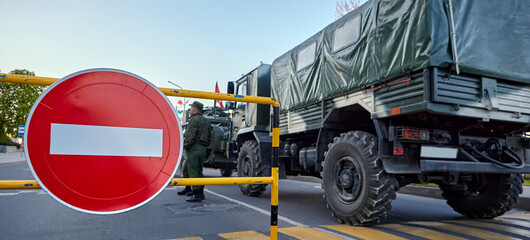Soldiers stand near the car against the background of the STOP sign.