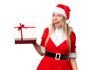 Young blonde woman with christmas hat and holding a gift over isolated chroma key background with surprise and shocked facial expression