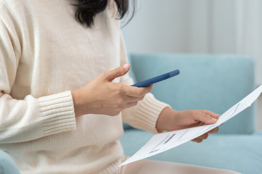 Modern woman use phone to scan barcode or QR codes to pay credit card bill after receive document invoice. payment, receive, paying electricity, digital payments without money, technology, scanning