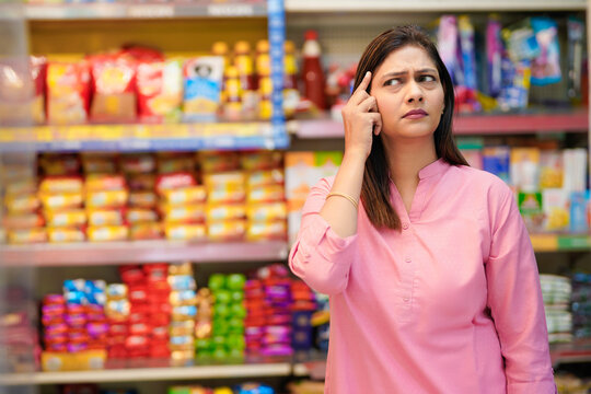 Indian woman thinking or remind at grocery shop.