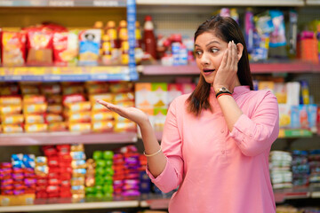 Indian woman giving expression for amazing offers and discount at grocery shop.