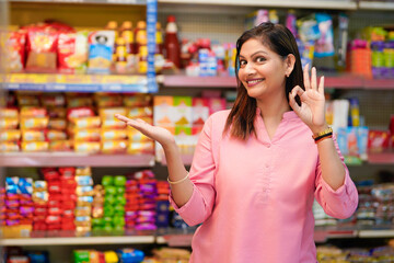 Indian woman giving expression for amazing offers and discount at grocery shop.
